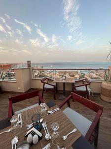 a restaurant with tables and a view of the ocean at SWISS Dive Resort Hurghada in Hurghada