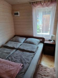 a bedroom with two beds and a window at Domek Letni in Gdynia
