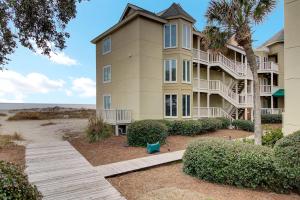 an apartment building with a pathway leading to the beach at 204 B Port O Call by AvantStay Beachfront Condo in Isle of Palms
