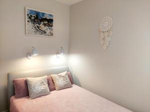 ein Schlafzimmer mit einem rosa Bett mit zwei Kissen in der Unterkunft Apartament Morze Sztuki II, Jantar in Jantar