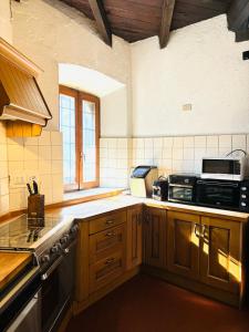 La cuisine est équipée de placards en bois et d'un four avec plaques de cuisson. dans l'établissement CASTELLO DEL 1100 CON VISTA e JACUZZI IN VALTELLINA, à Mazzo di Valtellina