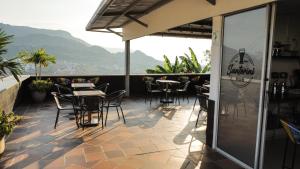 a restaurant with tables and chairs on a balcony at Hotel Santorini in San Gil