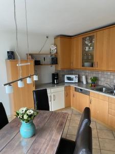 a kitchen with a wooden table with a vase of flowers on it at Artgerecht Naturverliebt in Bad Berleburg