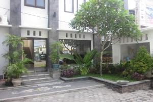 a building with trees and plants in front of it at Hotel Warta Dua in Denpasar