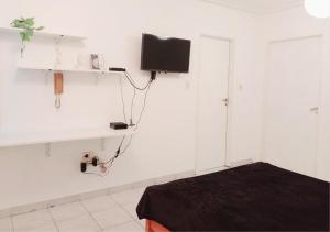 a room with a bed and a tv on the wall at Hermoso Apart Barrio Sur in San Miguel de Tucumán