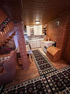 a kitchen with a brick wall and a kitchen with rugs at Chalet Hilltop Kodra e Diellit Popovo Sapka in Tetovo