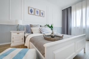 a white bedroom with a bed with a basket on it at Apartamenty Tespis - Francuska Atal Park PREMIUM in Katowice