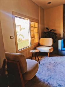 a living room with a chair and a window at Aurora sky view suite in Sheikh Zayed