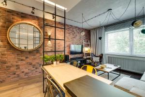 a living room with a brick wall at Apartamenty Tespis - Francuska Atal Park PREMIUM in Katowice