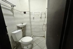 a small bathroom with a toilet and a sink at Hotel Warta Dua in Denpasar