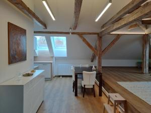 Boletice的住宿－Loft Polná，一间厨房和带木梁的用餐室