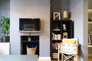 a living room with a tv and a book shelf at Townhouse in trendy suburb of Hoole in Chester