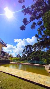 a body of water with the sun in the sky at Pousada das Montanhas in Monte Verde