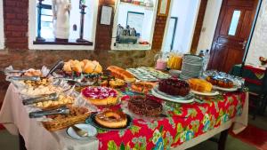 a table with many different types of pastries on it at Pousada das Montanhas in Monte Verde