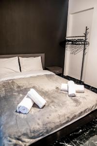 dos toallas están sentadas en una cama en un dormitorio en GM apartment experience, en Atenas
