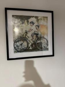 a framed picture of two people riding a bike at Japandi themed London Apartment in Thornton Heath