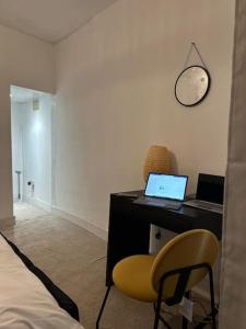 um quarto com uma secretária, um computador portátil e uma cadeira. em Japandi themed London Apartment em Thornton Heath