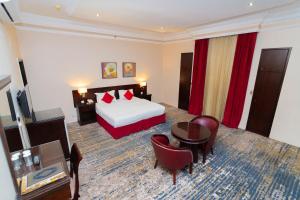فندق دار الريس - Dar Raies Hotel في مكة المكرمة: غرفة فندقية بسرير وطاولة وكراسي