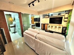 sala de estar con sofá y TV de pantalla plana en JADE, BLOCO A, APT 1209 · Hotel Jade, 2 quartos, parque sul, vista livre, en Brasilia
