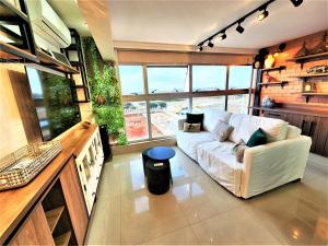 sala de estar con sofá blanco y ventana grande en JADE, BLOCO A, APT 1209 · Hotel Jade, 2 quartos, parque sul, vista livre, en Brasilia