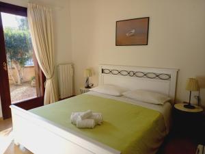 una camera da letto con un letto e due asciugamani di L'Alloggio-Not just rooms a Olbia