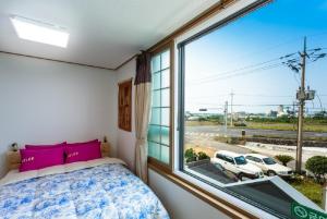 Postel nebo postele na pokoji v ubytování Jeju Wayo Pension