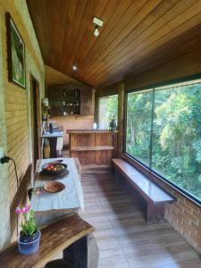 Un porche cubierto de una casa con bancos en Chalé da Lua - Parte Alta Parque Nacional de Itatiaia, en Itamonte