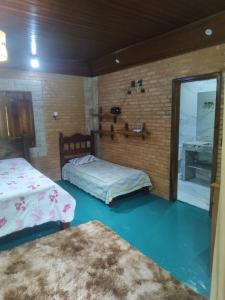 Un dormitorio con dos camas y una ventana. en Chalé da Lua - Parte Alta Parque Nacional de Itatiaia, en Itamonte