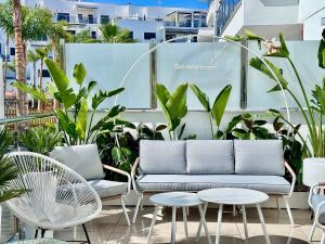 a patio with a couch and tables and plants at Aguacate Beach Apartamentos Playa Granada in Motril