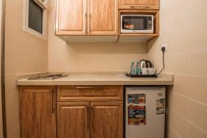 麥地那的住宿－انوار احد，一间带木制橱柜和冰箱的小厨房