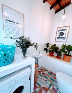 a laundry room with a washing machine and potted plants at Sunny & Charming Oeiras Historical Center House in Oeiras