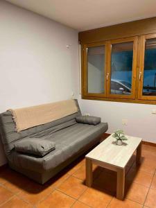 een woonkamer met een bank en een tafel bij Piso Pineta in Bielsa