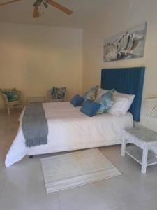 una camera da letto con un grande letto bianco con accenti blu di Tropicana guesthouse a Ponta do Ouro