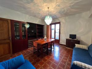 sala de estar con mesa y sofá azul en LA ROSA DEI VENTI en Villafranca Tirrena