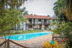 eine Villa mit einem Pool vor einem Haus in der Unterkunft Pousada Sargi&mar in Uruçuca
