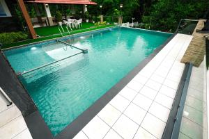 a large swimming pool with blue water at Athirappilly Rainland Resort in Athirappilly