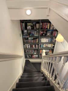 a staircase with a book shelf filled with books at Homestay near Roundhay Park, North Leeds in Leeds