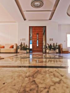 a lobby with couches and a wooden door at Royal Elegance Room in Sheikh Zayed