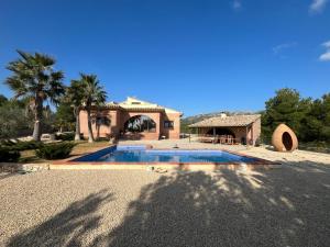 una casa con piscina frente a ella en Villa Ca LAbril piscina privada Wifi AC, en Les tres Cales
