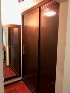 a large wooden closet in a room with a mirror at Pousada dos Girassóis in Pipa