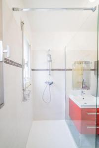 ein weißes Bad mit einer Dusche und einem Waschbecken in der Unterkunft #Le Concorde - Centre-ville - Terrasse - Parking in Brive-la-Gaillarde