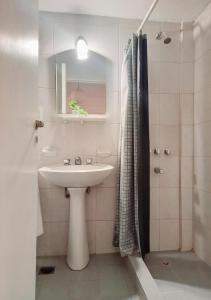a white bathroom with a sink and a shower at Hermoso Apart Barrio Sur in San Miguel de Tucumán