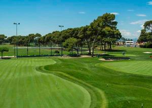 a view of a golf course with a green field at Apartamentos Mediterráneo en Playa Heliópolis Benicasim in Benicàssim