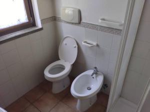 een kleine badkamer met een toilet en een wastafel bij Appartamento in villa nel bosco in Arrone