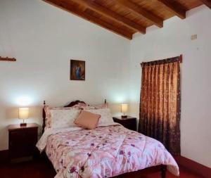 a bedroom with a bed and two night stands with lamps at Yoly's House in Caraz