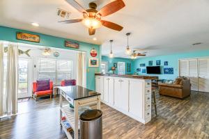 a living room with blue walls and a ceiling fan at Dock and Bay Access Rockport Home on Canal in Rockport