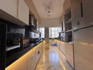 a large kitchen with white cabinets and black appliances at House of Luxury 8 in Mumbai
