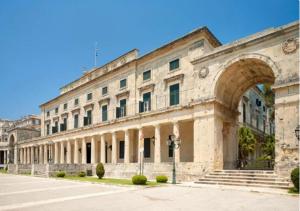 - un grand bâtiment en pierre avec une arche en face dans l'établissement The Dreamy Loft Corfu, à Corfou