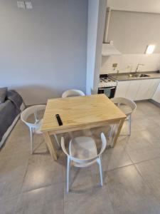 een houten tafel en stoelen in een keuken bij Austral Lofts in Puerto Madryn