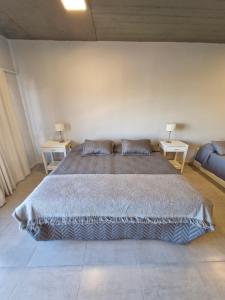 een slaapkamer met een groot bed en twee nachtkastjes bij Austral Lofts in Puerto Madryn